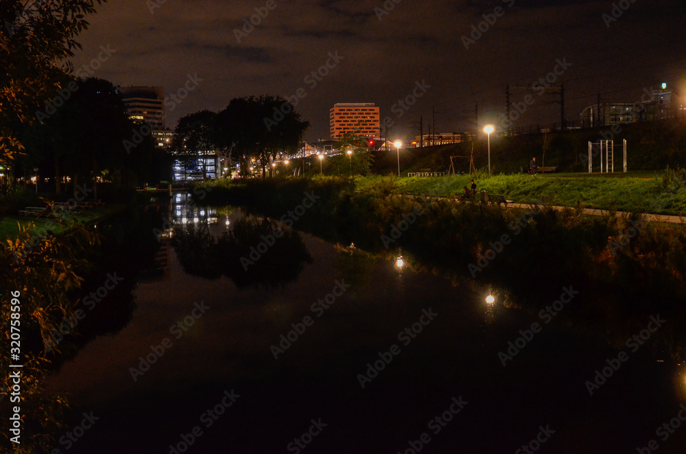 Amsterdam, Netherlands, August 2019. Night view of the modern suburbs. Modern buildings face the canals.