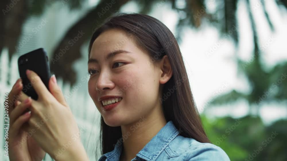 Handheld view of Vietnamese woman using smart phone. Shot with RED helium camera in 8K Handheld view of Vietnamese woman using smart phone. Shot with RED helium camera in 8K
