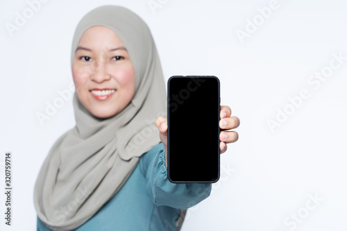 Muslim female showing mobile phone towards camera.