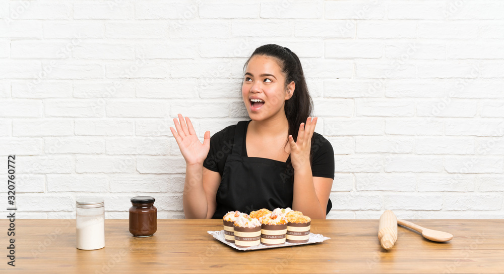 Young teenager Asian girl with lots of muffin cake with surprise facial expression Young teenager Asian girl with lots of muffin cake with surprise facial expression