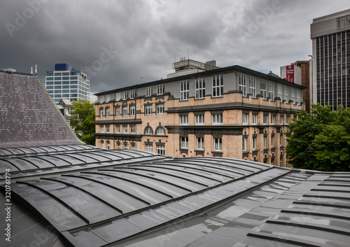 Museum Auckland New Zealand. Toi o Tamaki.  View outside over the roofs of the Auckland art gallery to a brick building.  photo