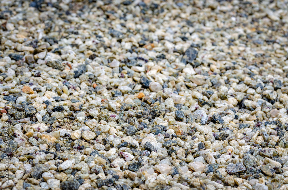 Multi-colored, smooth pebbles on the ground as a background. Multi-colored, smooth pebbles on the ground as a background.