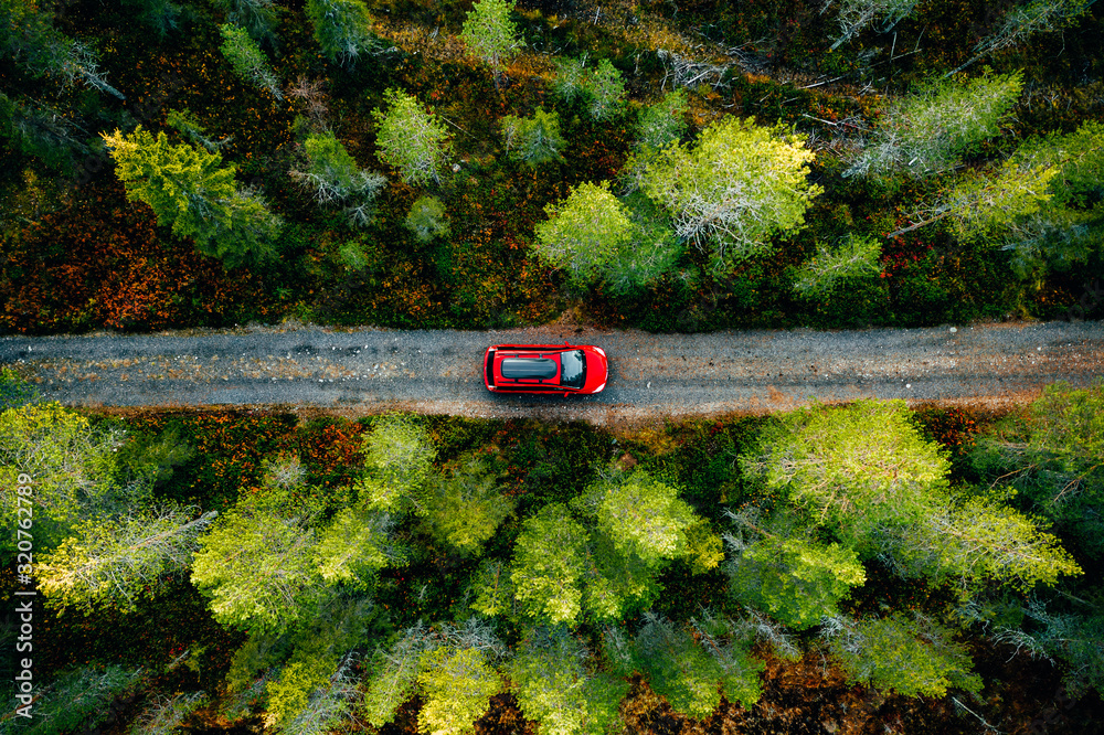 Aerial view of red car with a roof rack on a country road in Finland - obrazy, fototapety, plakaty 