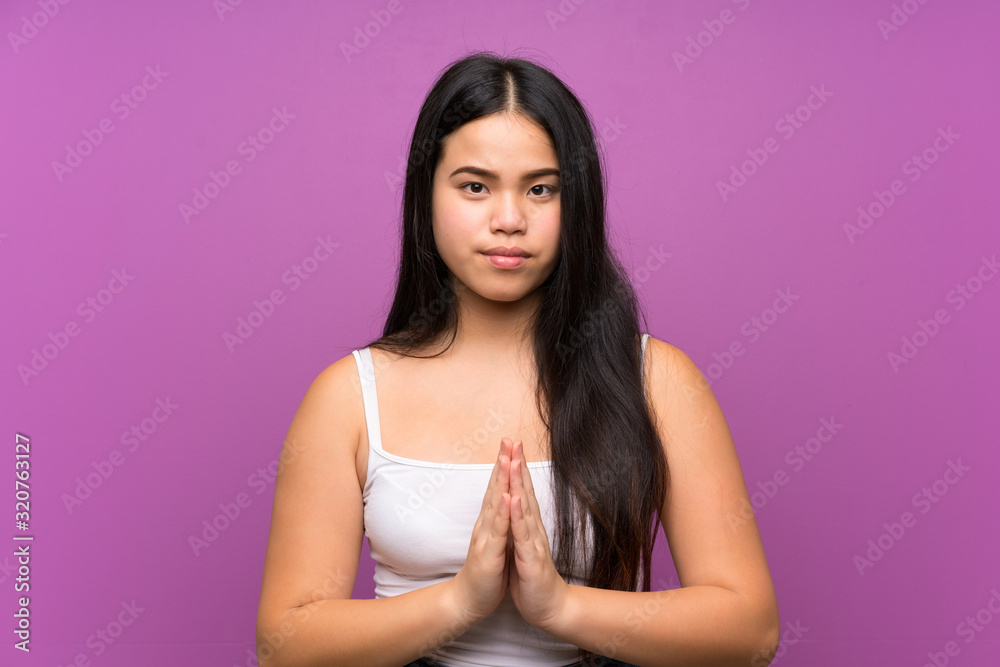 Young teenager Asian girl over isolated purple background pleading Young teenager Asian girl over isolated purple background pleading