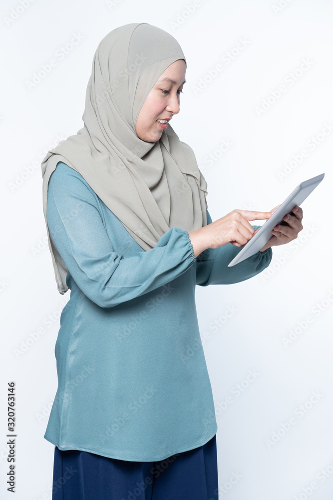 Female muslim woman using a tablet device. Female muslim woman using a tablet device.