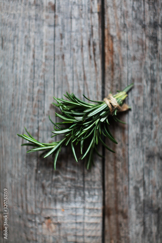 closeup of a fresh green rosemary leaves on wooden background