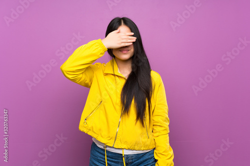Young teenager Asian girl over isolated purple background covering eyes by hands. Do not want to see something © luismolinero