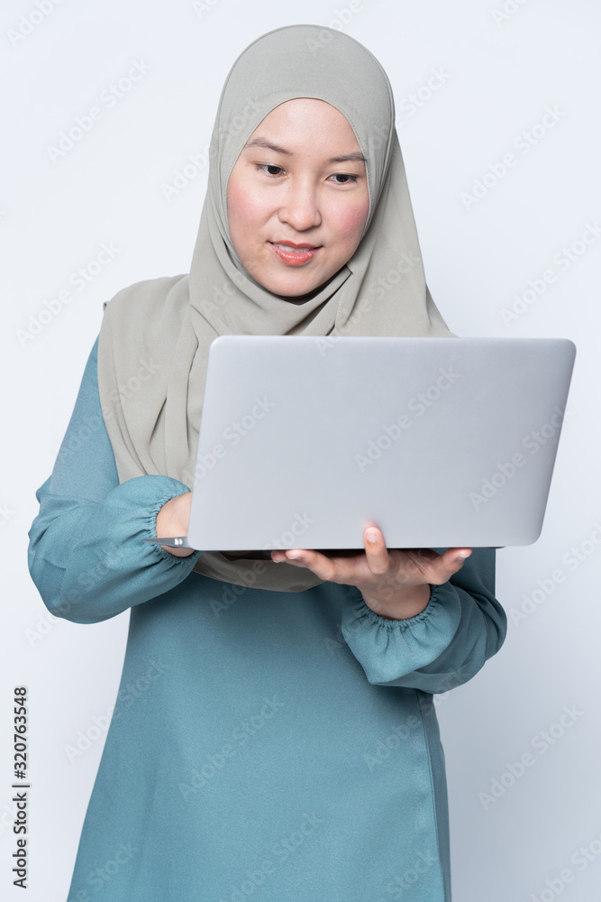 Muslim woman using a laptop with facial expression. Muslim woman using a laptop with facial expression.