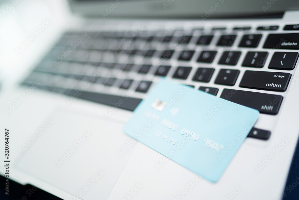 Female muslim woman using laptop while holding credit card. Female muslim woman using laptop while holding credit card.