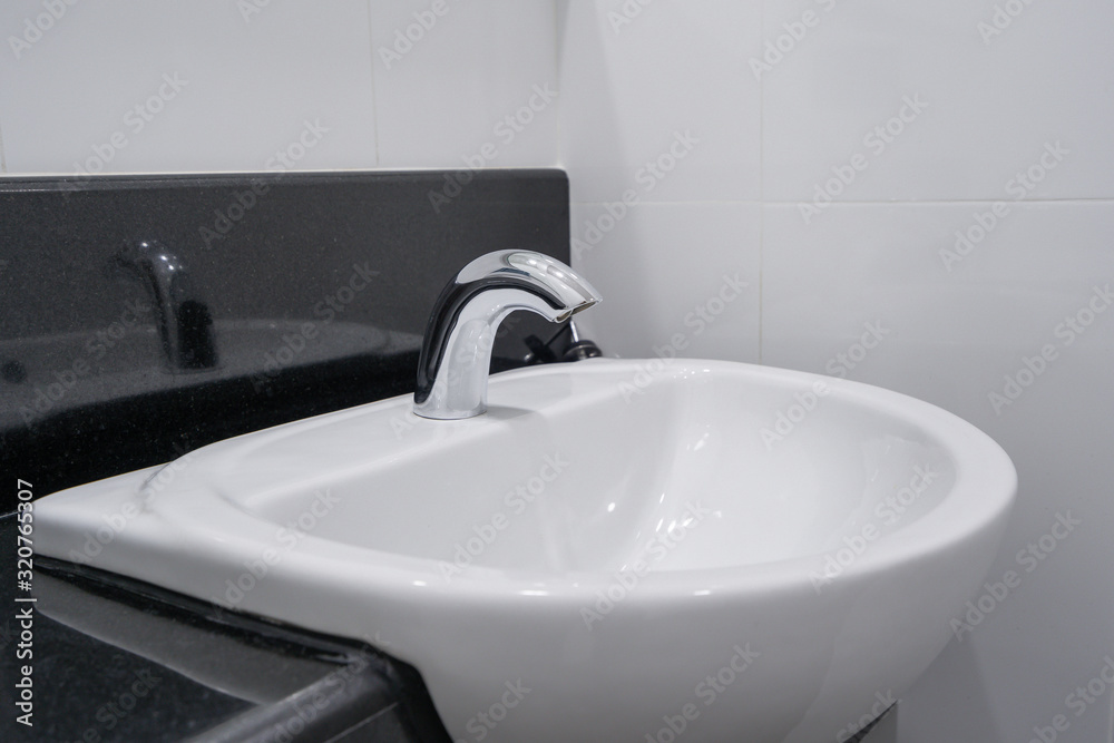 Fototapeta premium Modern faucet and white ceramic washbasin sink bathroom interior building decoration