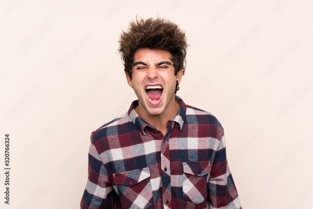 Young caucasian man shouting to the front with mouth wide open Young caucasian man shouting to the front with mouth wide open
