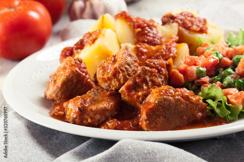 Braised pork meat stew served with potatoes