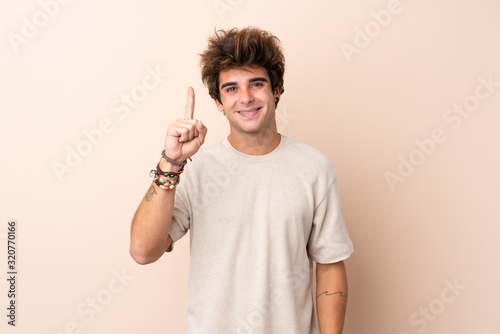 Young caucasian man over isolated background pointing with the index finger a great idea