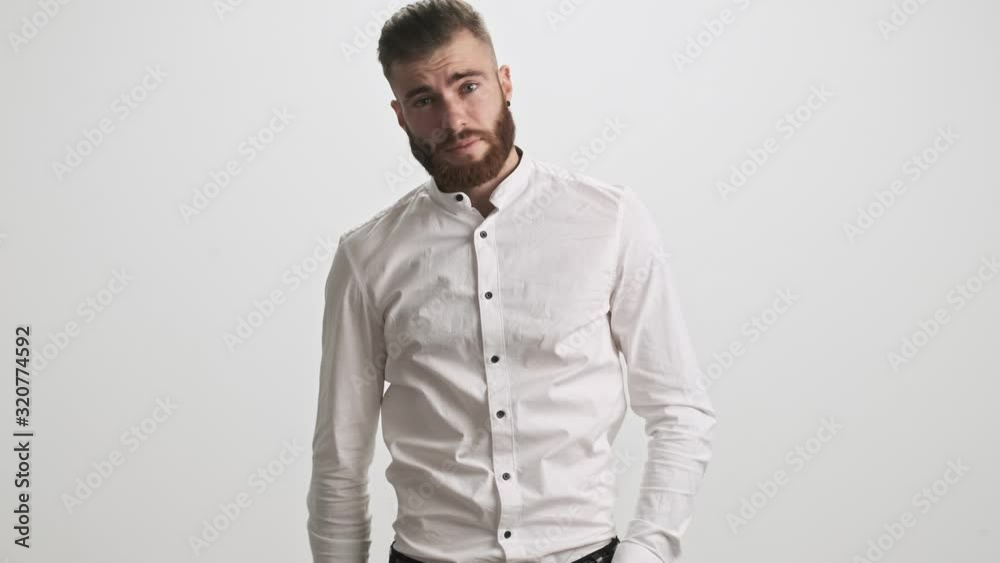 A puzzled bearded man is touching his forehead isolated over white wall background A puzzled bearded man is touching his forehead isolated over white wall background