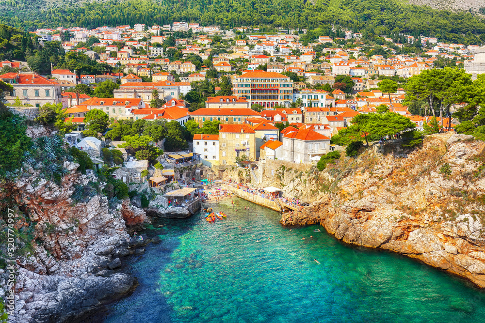 Aerial view at famous travel destination city of Dubrovnik -  Suluci beach and old  city on a sunny day.