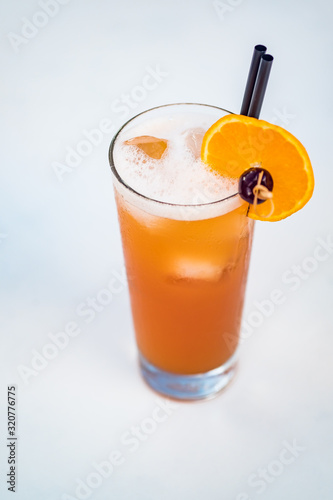 Close-up of orange alcoholic cocktail in a tall glass