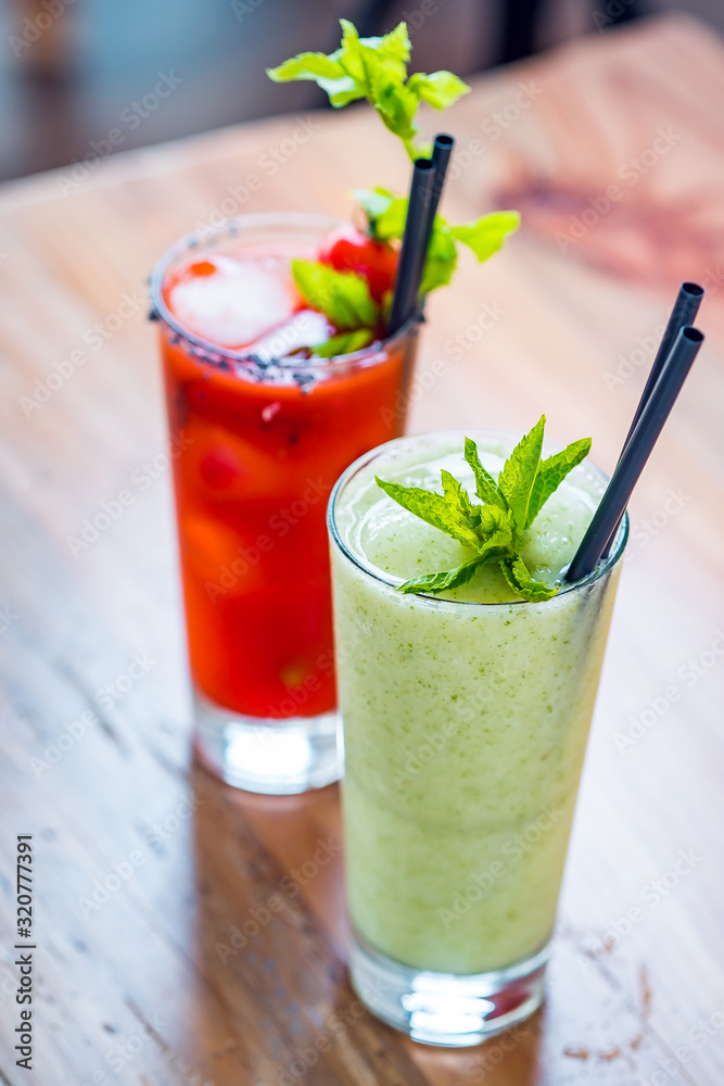 Contrast image of bloody mary cocktail alcoholic drink and green healthy mint smoothie. Contrast image of bloody mary cocktail alcoholic drink and green healthy mint smoothie.