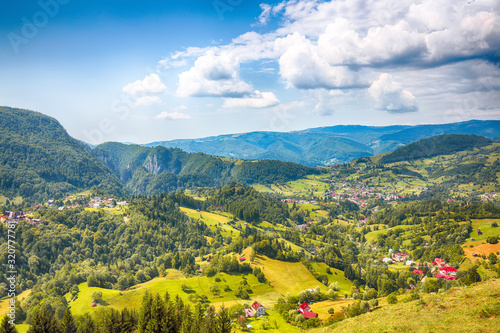 Stunning alpine landscape with green fields and Piatra Craiului mountains in Dambovicioara Commune photo
