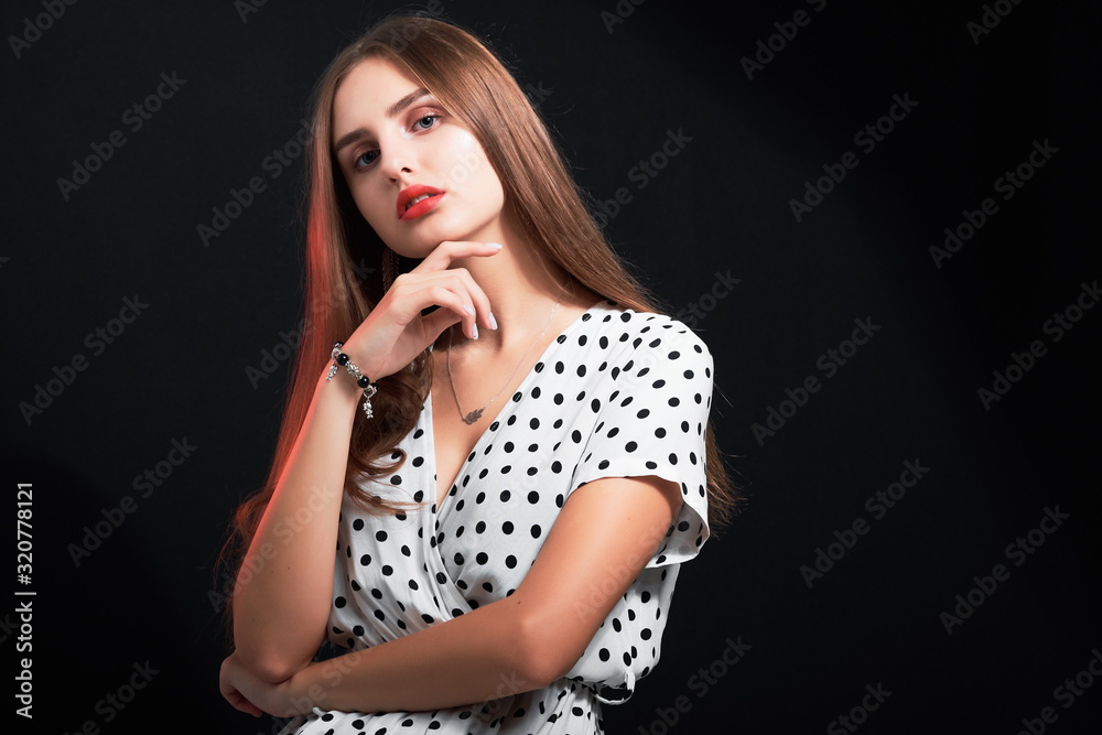 Portrait of a young attractive girl with long hair and red lips against black background. Portrait of a young attractive girl with long hair and red lips against black background.