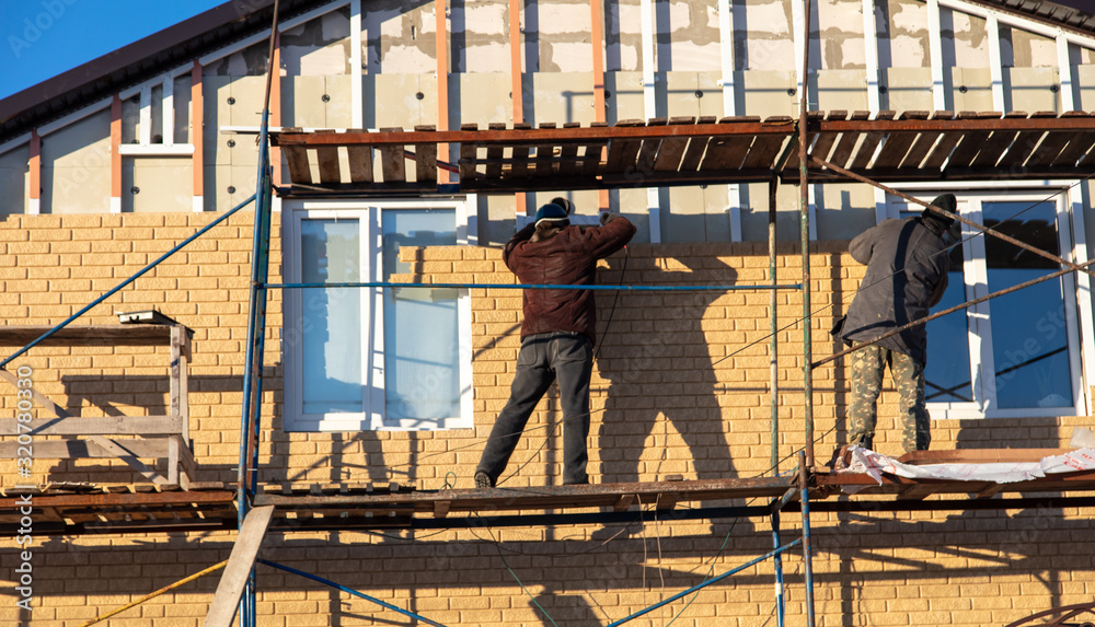 Naklejka premium Installation of siding on the walls of the house
