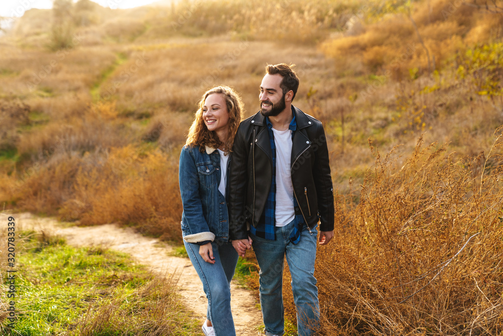 Image of beautiful couple dating and walking together in countryside