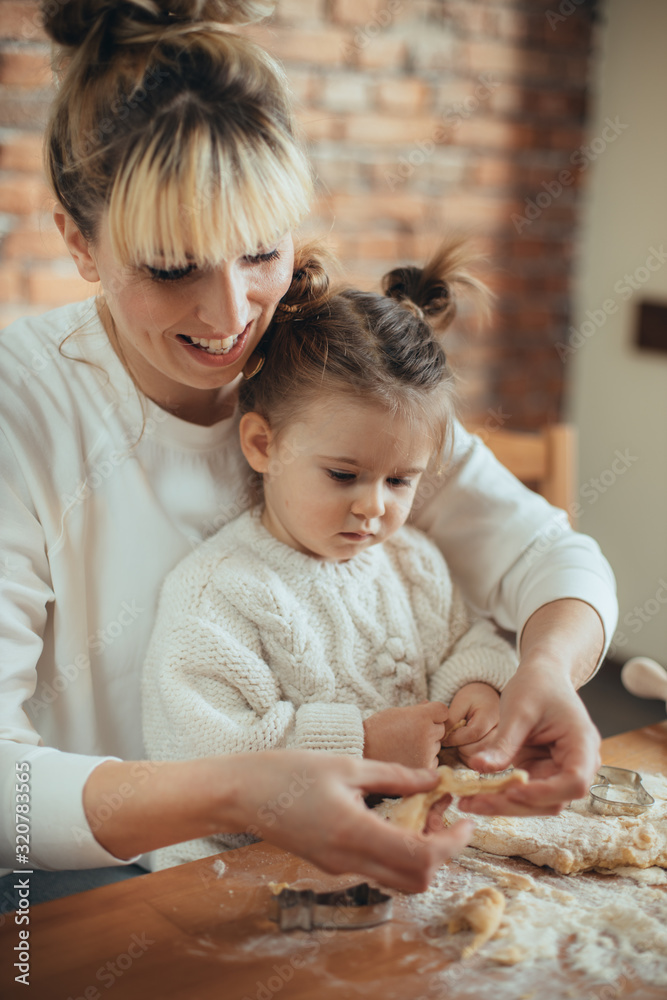 Mother and daughter baking cookies in their kitchen