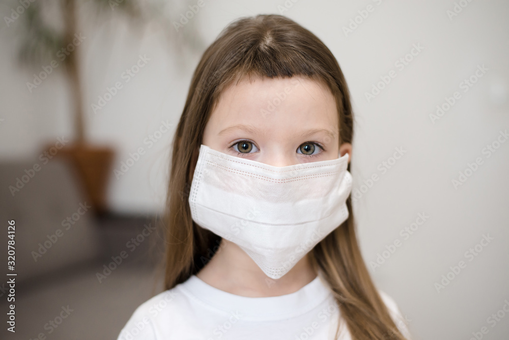 Sick little girl wearing a medical mask against virus closeup lokking at camera - Concept of coronavirus protection Sick little girl wearing a medical mask against virus closeup lokking at camera - Concept of coronavirus protection