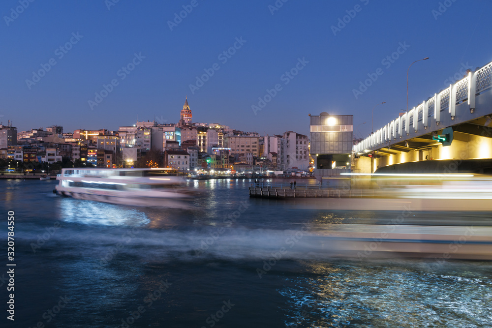 Fototapeta premium Istanbul, Turkey - Jan 10, 2020: Ferry boat in Golden Horn at the Galata Bridge with Galata Tower in background, Istanbul, Turkey, Europe
