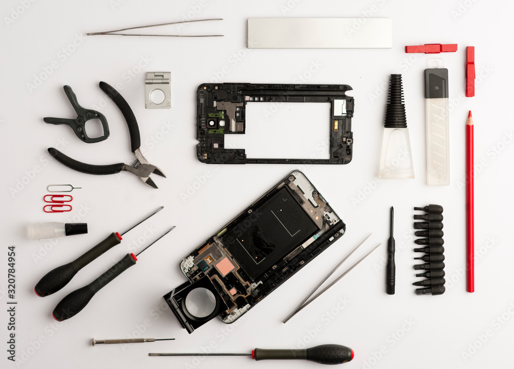 set of objects mobile repair on white background, mobile workshop concept, various tools, broken phone, magnifying glass, glue, screwdrivers, top view on white background