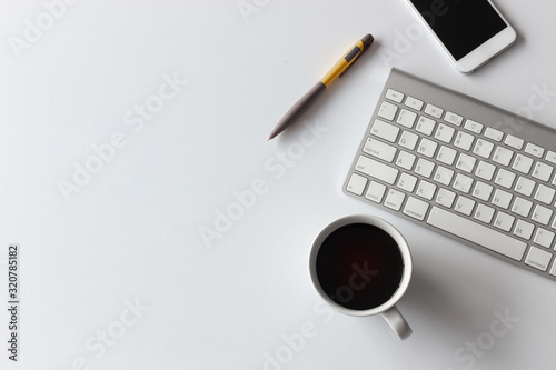 top view office table desk. coffee cup, smartphone, pen, keyboard and other office equipment on white background