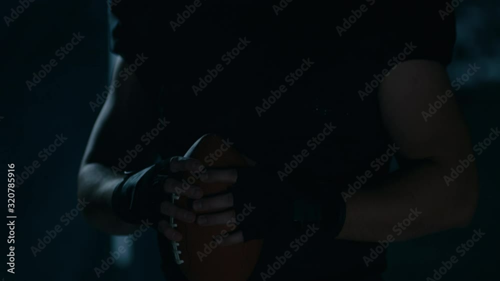 CU Portrait of American football player in protective uniform posing against bright flashing lights. Shot on ARRI Alexa Mini 60 FPS slow motion CU Portrait of American football player in protective uniform posing against bright flashing lights. Shot on ARRI Alexa Mini 60 FPS slow motion