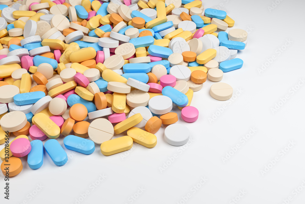 Heap of various assorted colorful pills at the white table. Top view with copy space. Pharmaceutical industry and health care concept.