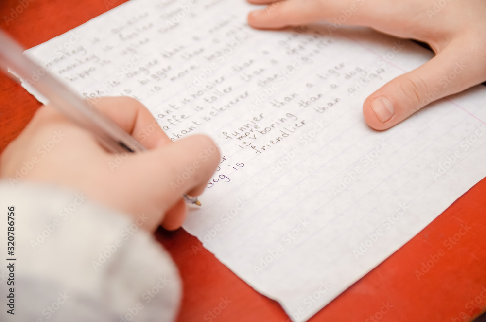 Obraz premium girl does a task in English, writes in a notebook close-up