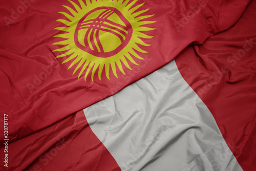 waving colorful flag of peru and national flag of kyrgyzstan.
