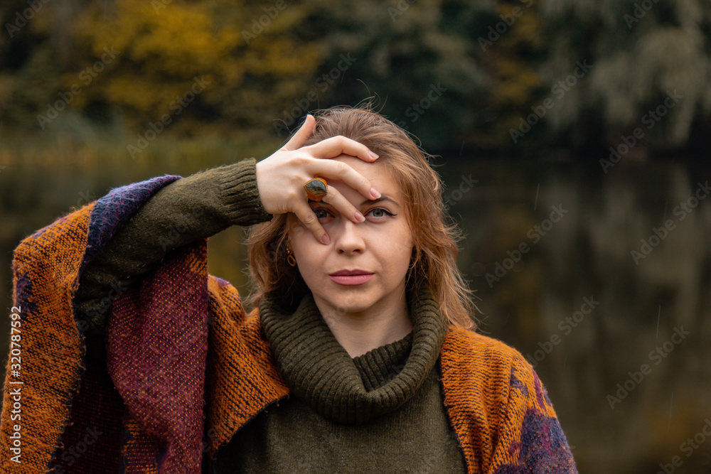 hide and seek. the girl covered her face with her hands. Close-up portrait on a lake background. The concept of female pain, sadness, violence, depression, loneliness. hide and seek. the girl covered her face with her hands. Close-up portrait on a lake background. The concept of female pain, sadness, violence, depression, loneliness.