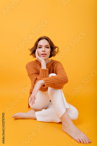 Foto Barefooted winsome girl sitting with legs crossed