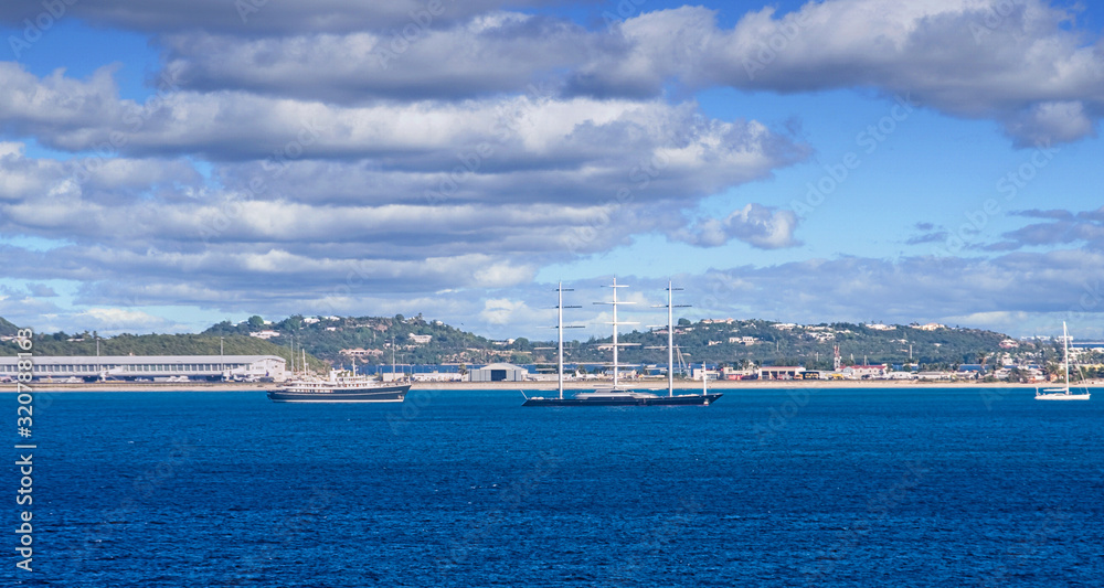 The coast off a tropical island with sailing yachts