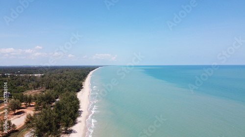 Aerial view of beautiful beach with clear blue sea was and sky in background.
