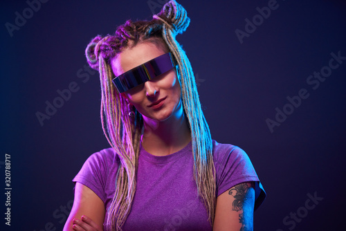 Smiling girl in sunglasses looking at camera in neon light © nuclear_lily