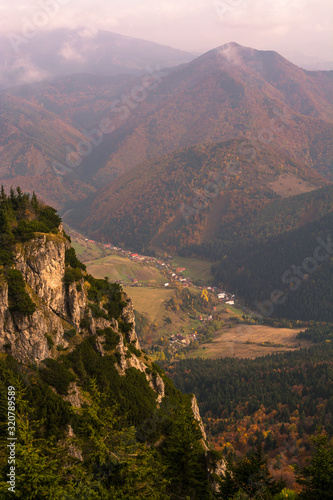 A picturesque village in a valley between mountains on autumn © majochudy