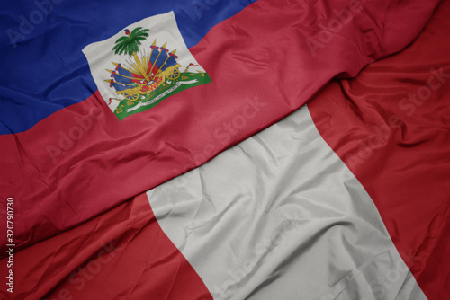 waving colorful flag of peru and national flag of haiti. Fototapet