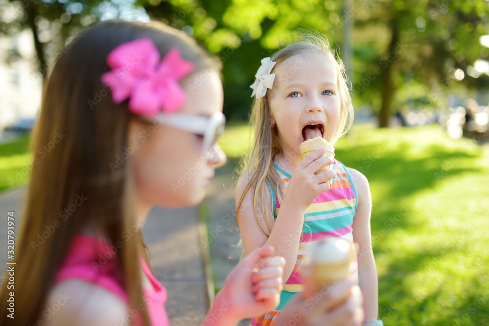 Cute little children eating tasty fresh ice cream in sunny summer park. Kids eating sweets. Cute little children eating tasty fresh ice cream in sunny summer park. Kids eating sweets.