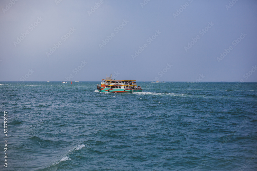 Boat in  sea on background of island. Blue water, paradise relaxation. Place under the text, advertising tours. Sea travel