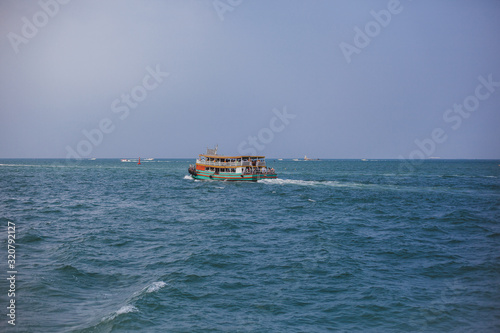 Boat in sea on background of island. Blue water, paradise relaxation. Place under the text, advertising tours. Sea travel