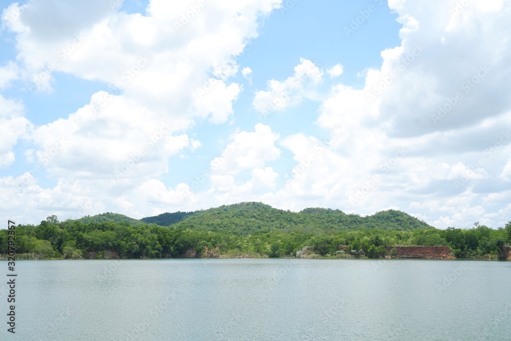 Beautiful lake green trees with nice blue sky white clouds .  I