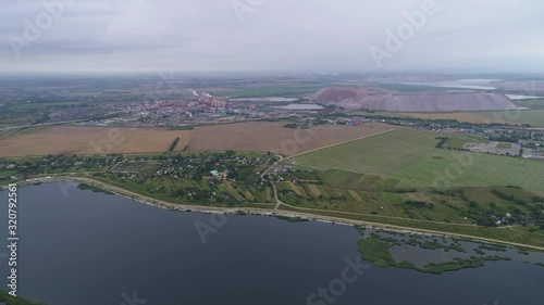 flight over the reservoir, opens a view of the potash enterprise and small villages, 4k photo