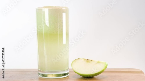 Hand putting down a glass of fresh green apple juice 
