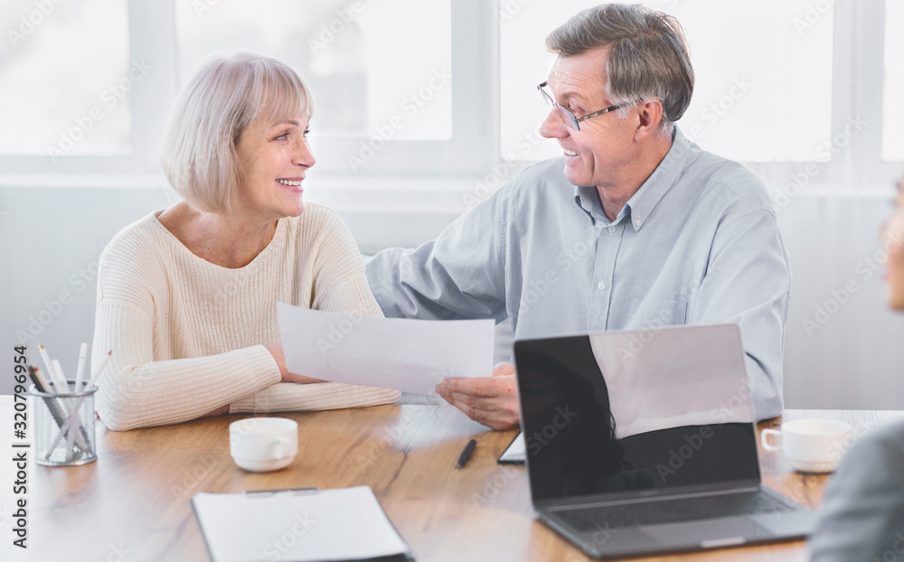Mature couple talking to financial advisor at office Mature couple talking to financial advisor at office