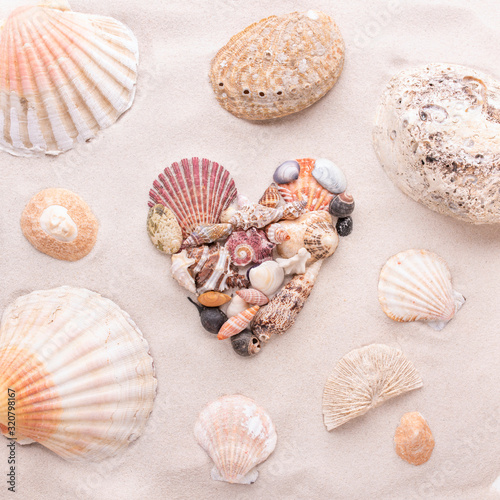 A heart made of small shells on the beach sand is love and St. Valentine s Day
