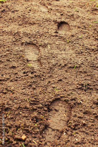Human boot footprints on brown rural ground